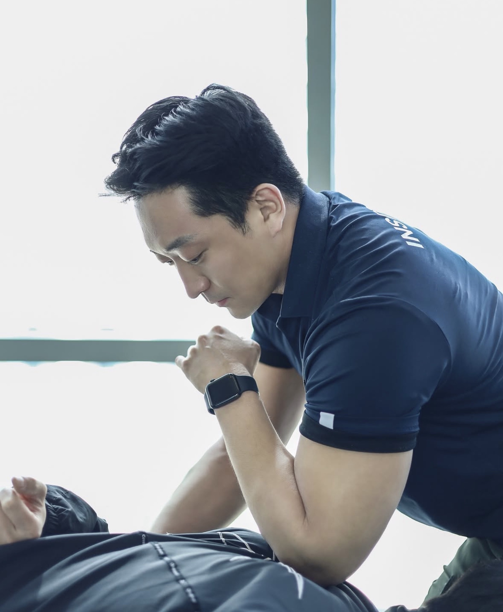 트레이너가 회원의 관절 움직임을 세심하게 확인하는 코칭 장면